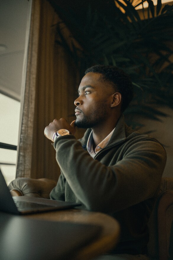 man thinking while looking out window