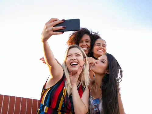 Group of women taking a picture with a cell phone