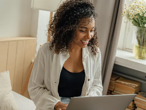 woman sitting on couch looking at laptop