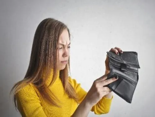 Woman looking into empty wallet
