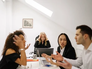 Employees arguing around a table