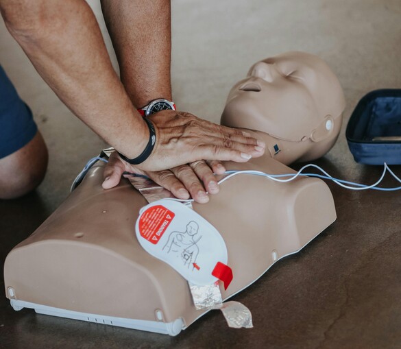 Hands of person doing CPR on training dummy