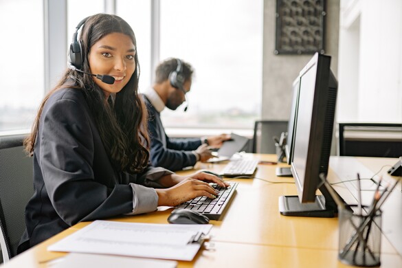 Customer service representative sitting at a desk with a headset on