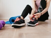 woman lacking up tennis shoes