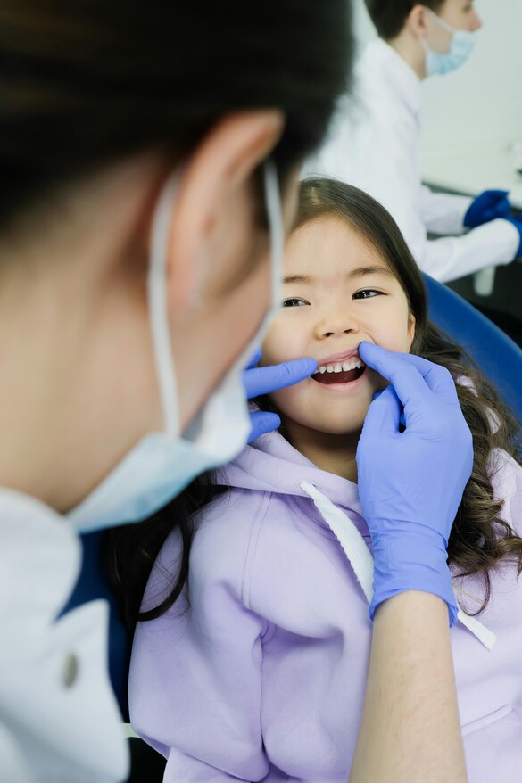 Child in purple sweatshirt getting dental checkup