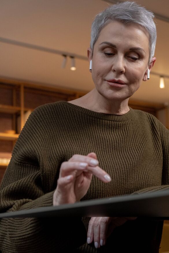 mature woman in brown sweater with airpods