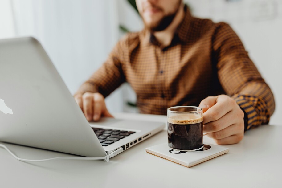 man looking a laptop with coffee