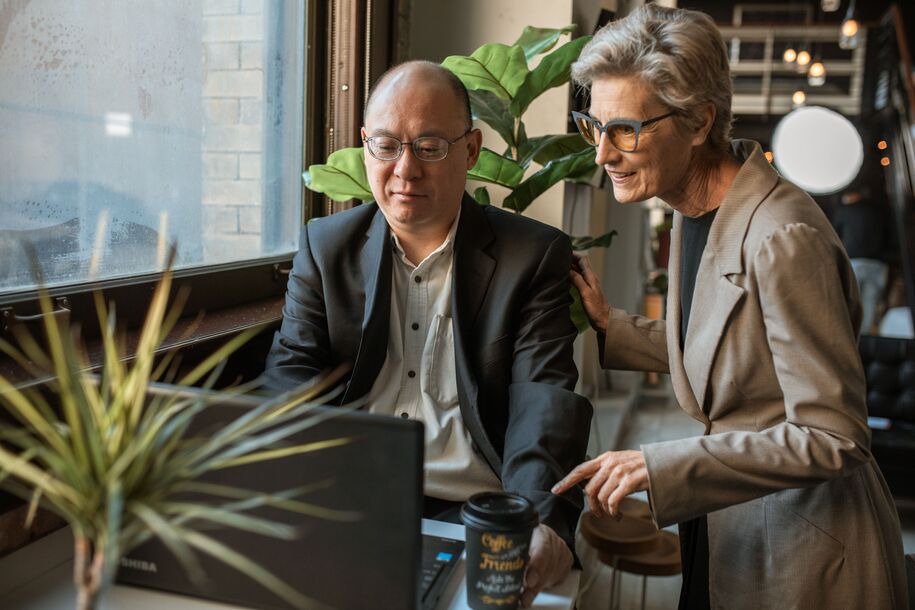 mature couple looking at laptop, surrounded by plants
