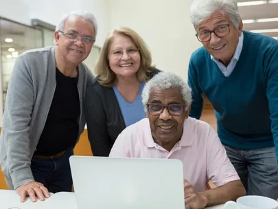 mature adults around a laptop